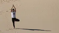 Seorang pria menghadiri kelas yoga yang diselenggarakan oleh komunitas YSYoga System di gurun Samalayuca, negara bagian Chihuahua, Meksiko pada 25 Mei 2019. Melakukan aktivitas yoga di tengah hawa panas diyakini dapat menambah energi di dalam tubuh. (Herika MARTINEZ/AFP)