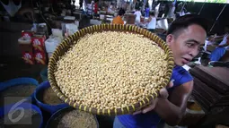 Pekerja tengah mengangkat kacang kedelai untuk dijadikan bahan dasar pembuatan tahu di Jakarta, Rabu (6/1/). Dari kebutuhan sekitar 2,5 juta ton per tahun, 1,7 juta ton diantaranya harus dipenuhi dari impor. (Liputan6.com/Angga Yuniar)