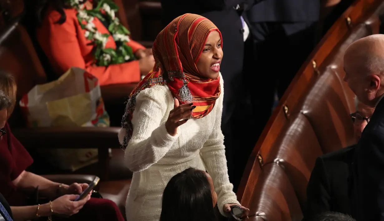 Senator Amerika Serikat (AS) Ilhan Omar berbincang saat mengikuti pelantikan di Gedung Kongres AS, Capitol, Washington, Kamis (3/1). Omar menjadi legislator federal pertama yang dilantik menggunakan hijab. (MARK WILSON/GETTY IMAGES NORTH AMERICA/AFP)