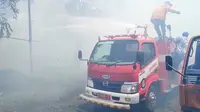 Petugas Pemadam Kebakaran Banyuwangi berusaha memadamkan api yang melalap sebuah kios di Terminal Brawijaya Banyuwangi (Hermawan Arifianto/Liputan6.com)