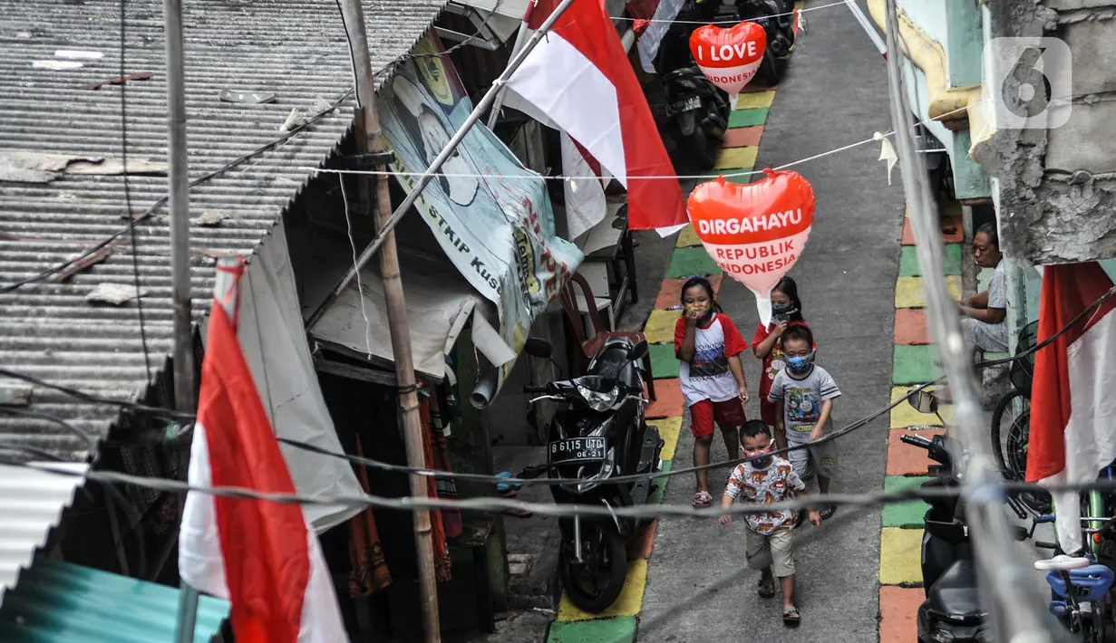 Anak-anak melintas di Gang A, RT 10/11, Pademangan Timur, Jakarta, Rabu (5/8/2020). Ide menghias gang tersebut dicetus oleh Ketua RT setempat, Farli (48), dan disambut antusias oleh warga yang turut membantu pemasangan atribut HUT ke-75 RI secara swadaya. (merdeka.com/Iqbal S. Nugroho)