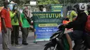 Petugas Satpol PP memberitahu warga terkait penutupan kawasan Kebun Binatang Ragunan, Jakarta, Minggu (16/5/2021). Sejumlah kawasan wisata di DKI Jakarta ditutup sementara untuk umum hingga 18 Mei 2021 untuk pemberlakukan penguatan protokol kesehatan COVID-19. (Liputan6.com/Helmi Fithriansyah)