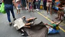 Aksi anak-anak jalanan saat melakukan tarian singa dengan kepala singa yang terbuat dari kardus saat menghibur pejalan kaki  untuk menyambut Tahun Baru Imlek di Manila (4/2). (AFP Photo/Ted Aljibe)