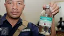 Petugas menunjukkan botol obat yang disita dalam penggerebekan dua klinik aborsi ilegal di kawasan Cikini, Jakarta, Rabu (24/2). Sebanyak 9 orang diduga pelaku praktik aborsi sekitar 5.400 janin bayi diamankan petugas. (Liputan6.com/Gempur M Surya)