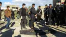 Polisi Irak berdiri di dekat jasad yang dieksekusi oleh kelompok ISIS di sebuah kuburan massal di Kota Ramadi, sebelah barat Baghdad, Selasa (26/1). Kuburan massal tersebut berisi sisa-sisa sekitar 40 jasad. (AFP/ MOADH AL-DULAIMI)