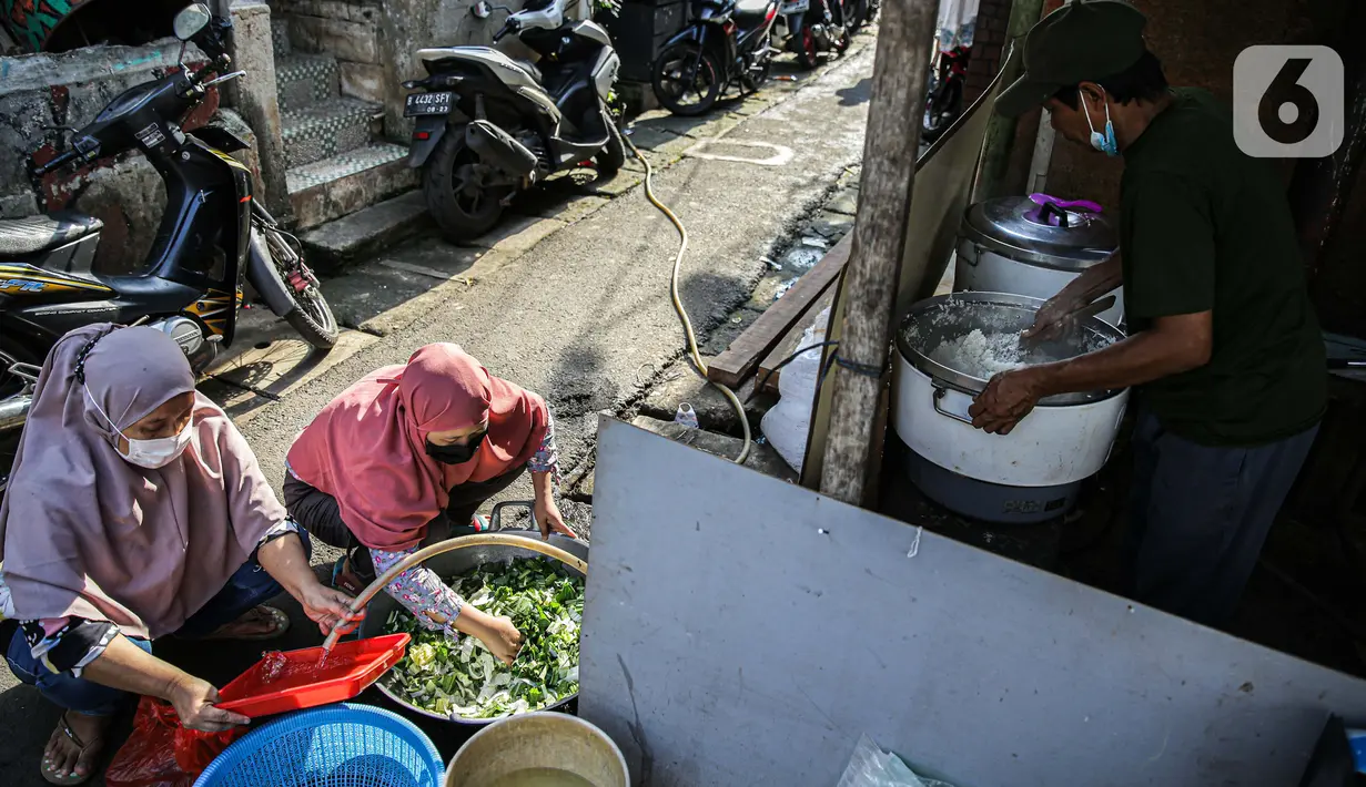 Warga menyiapkan bahan makanan untuk dibagikan di zona merah covid-19 Kelurahan Petogogan RT 006 RW 003, Jakarta, Selasa (22/6/2021). Dapur umum itu menyuplai kebutuhan makanan berat serta minuman untuk warga yang menjalani isolasi dan terdampak akibat COVID-19. (Liputann6.com/Faizal Fanani)