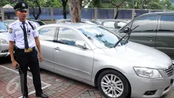 Petugas berdiri di dekat mobil Toyota Camry yang terparkir di halaman Gedung KPK, Jakarta, Senin (15/2). Mobil ini diamankan saat OTT terhadap Kepala Sub Direktorat Kasasi dan PK Perdata dan Khusus MA, Andri Tristianto Sutrisna (Liputan6.com/Helmi Afandi)