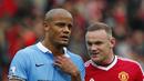 Pemain Manchester City, Vincent Kompany (kiri), berbincang dengan pemain Manchester United, Wayne Rooney, dalam lanjutan Liga Premier Inggris di Stadion Old Trafford, Inggris, Minggu (25/10/2015). (Reuters/Eddie Keogh)