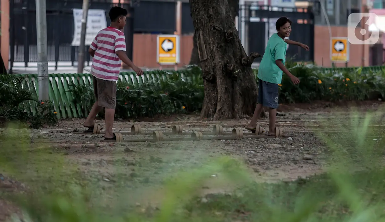Anak-anak bermain di Taman Tomang Rawa Kepa, Jakarta, Minggu (21/6/2020). Lokasi tersebut menjadi salah satu tempat alternatif liburan warga untuk menghilangkan kebosanan di tengah masa PSBB transisi. (Liputan6.com/Johan Tallo)