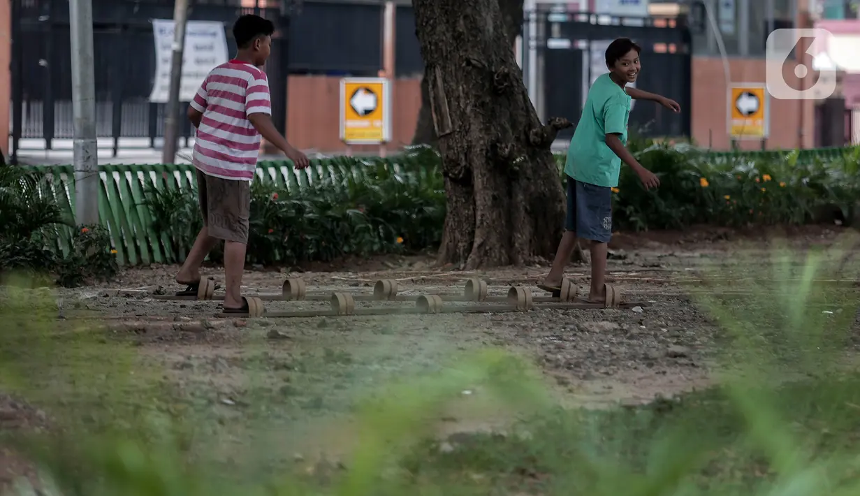 Anak-anak bermain di Taman Tomang Rawa Kepa, Jakarta, Minggu (21/6/2020). Lokasi tersebut menjadi salah satu tempat alternatif liburan warga untuk menghilangkan kebosanan di tengah masa PSBB transisi. (Liputan6.com/Johan Tallo)