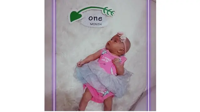 Baby Zunaira tampil menggemaskan saat pemotretan 1 bulan, ia tampak mengenakan baju berwarna pink lengkap dengan bandana.