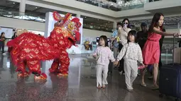 Penari barongsai menyambut wisatawan mancanegara (wisman) asal China yang tiba di bandara internasional Ngurah Rai di Bali, Minggu (22/1/2023). Penerbangan langsung turis China ke Bali dengan penerbangan maskapai Lion Air dari Shenzhen yang membawa sebanyak 210 pax. (AP Photo/Firdia Lisnawati)