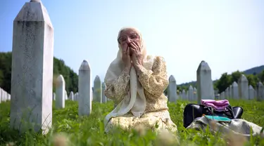 Seorang wanita muslim Bosnia berduka di samping makam kerabatnya, korban genosida Srebrenica, di Memorial Center, Potocari, Bosnia-Herzegovina, Selasa (11/7/2023). Ribuan orang berkumpul di Kota Srebrenica untuk memperingati 28 tahun satu-satunya genosida yang diakui Eropa sejak Perang Dunia II. (AP Photo/Armin Durgut)