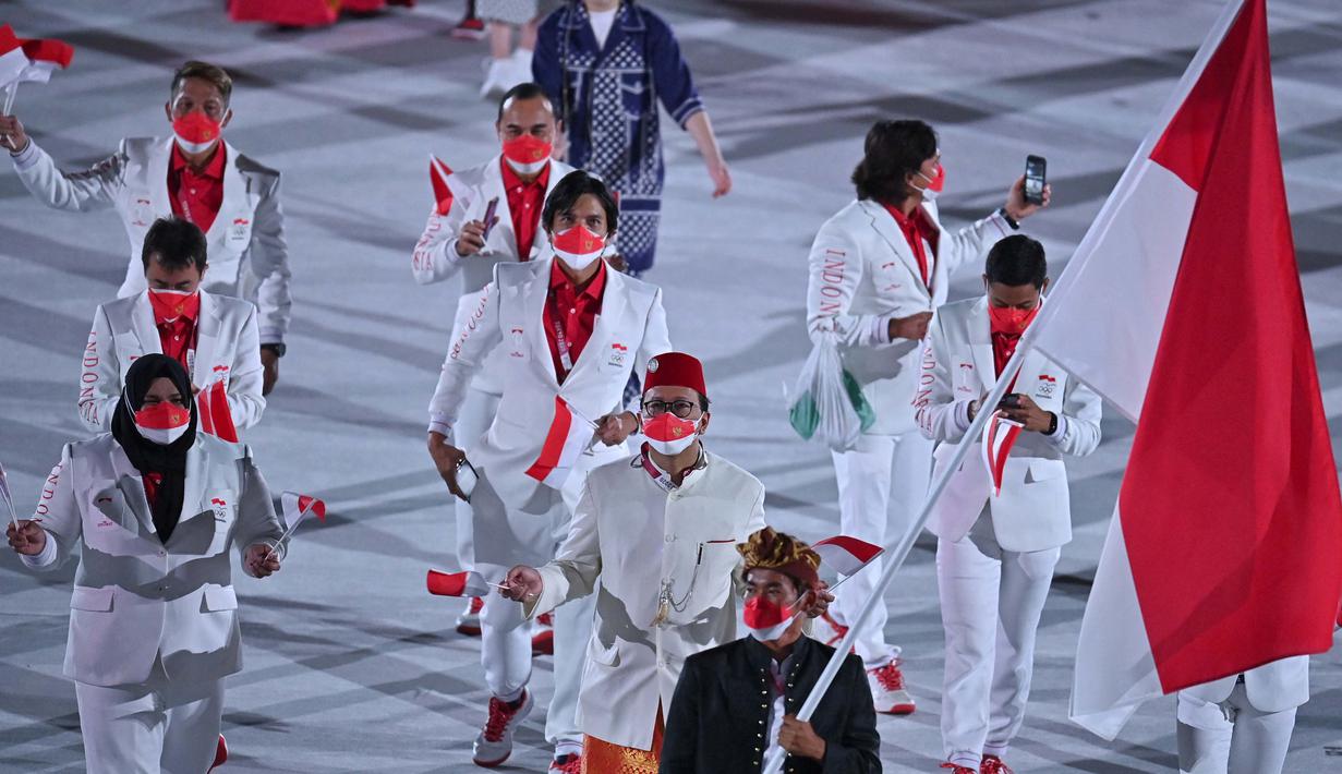 Rio Waida berada di barisan terdepan diikuti Chef de Mission Rosan P Roeslani yang mengenakan baju adat Betawi bernuansa putih dengan sarung dan peci Merah serta lifter nasional Nurul Akmal. (Foto: AFP/Ben Stansall)