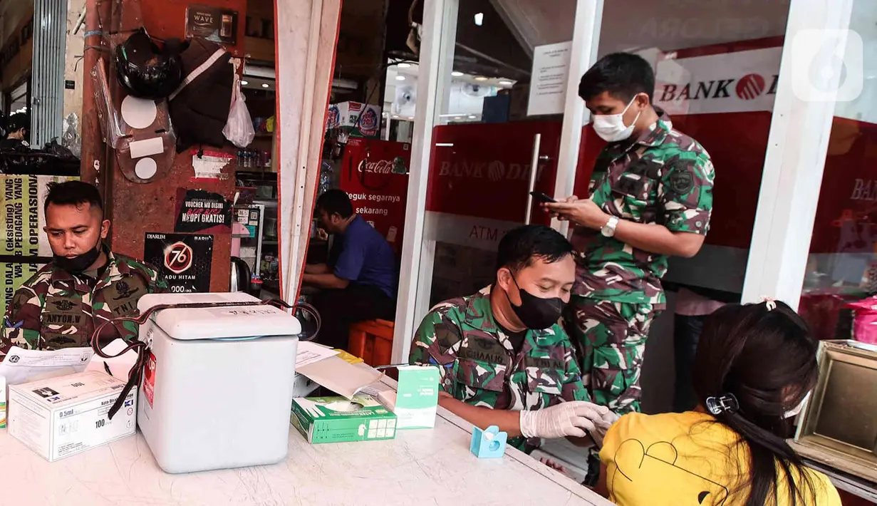 Anggota Marinir AL menyuntikan vaksin ketiga (booster) kepada warga di Pasar Palmerah, Jakarta, Selasa (19/4/2022). Satuan Tugas Penanganan Covid-19 merilis surat edaran yang mengatur pelaku perjalanan untuk keperluan mudik Idul Fitri 1443 H yakni vaksin booster. (Liputan6.com/Herman Zakharia)