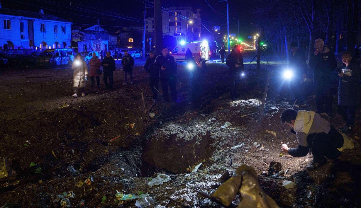 Permukiman warga sipil kembali menjadi sasaran serangan drone Rusia yang terjadi pada Kamis 16 April 2026 dini hari waktu setempat. Tampak dalam foto, warga melihat lubang tanah akibat serangan Rusia di permukiman penduduk, Kyiv, Ukraina, pada Kamis 16 April 2026. (AP Photo/Evgeniy Maloletka)