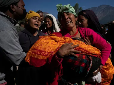 Seorang wanita menggendong jenazah cucunya yang tewas akibat gempa bumi di Distrik Jajarkot, barat laut Nepal, Minggu (5/11/2023). Gempa bumi Jumat malam di distrik tersebut menewaskan lebih dari 100 orang, sementara lebih dari 50 orang tewas di distrik tetangga Rukum, kata para pejabat. (AP Photo/Niranjan Shrestha)