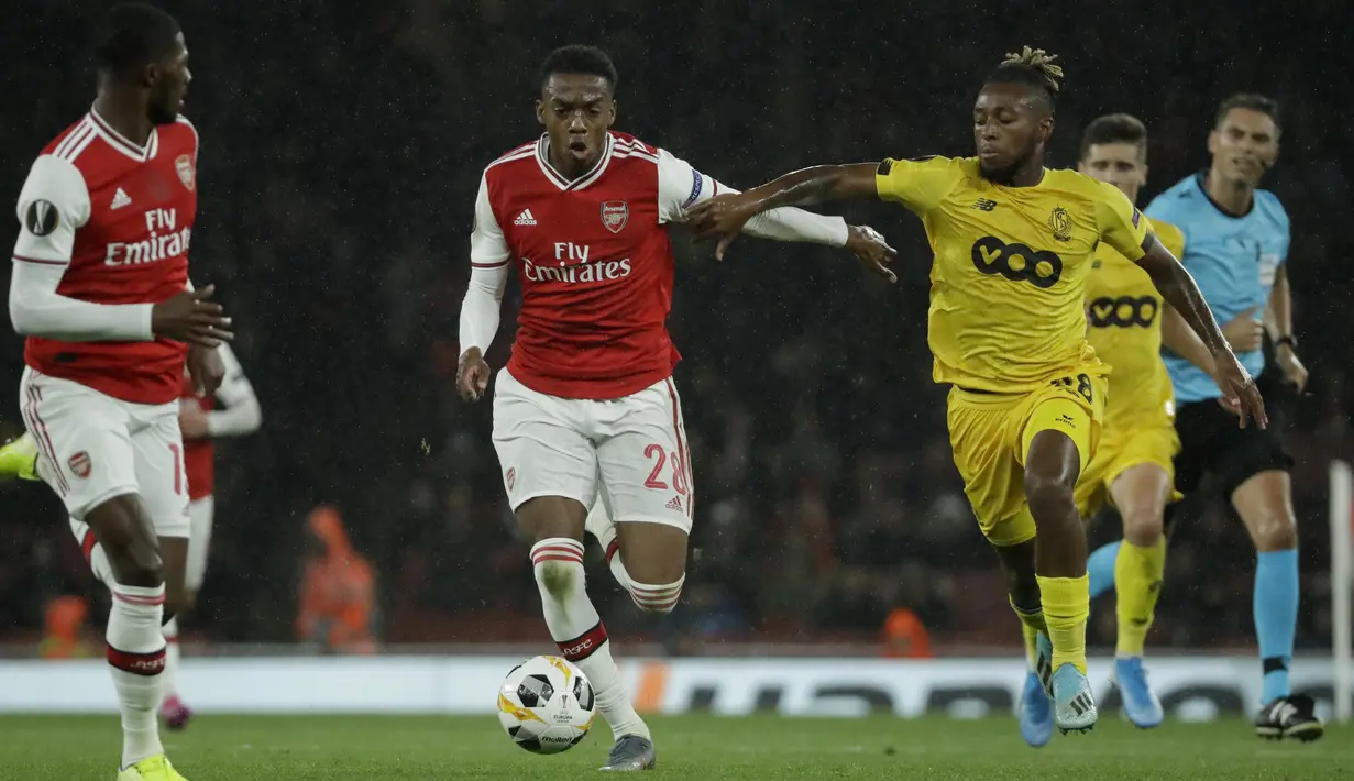 Gelandang Arsenal, Joe Willock (tengah) menggiring bola dari kawalan pemain Standard Liege, Samuel Bastien (kanan) pada lanjutan pertandingan grup F Liga Europa di Stadion Emirates, London (3/10/2019). Willock mencetak satu gol dan mengantar Arsenal menang telak 4-0. (AP Photo/Matt Dunham)