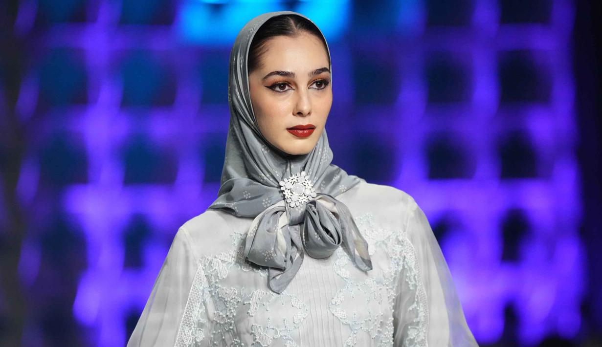 Diselenggarakan oleh Kementerian Perdagangan yang bekerja sama dengan Indonesian Fashion Chamber (IFC), acara ini bertujuan untuk mempromosikan modest fashion Indonesia ke pasar global. Tampak dalam foto, seorang model memamerkan karya desainer mode Indonesia Khanaan selama Jakarta Muslim Fashion Week, Kamis 6 November 2025. (AP Photo/Tatan Syuflana)