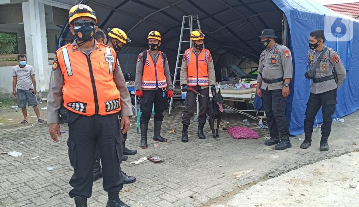 Polisi menggunakan anjing pelacak untuk mencari korban gempa bumi di bangunan Rumah Sakit Mitra Manakarra yang runtuh di Mamuju, Minggu (17/1/2021). Polri mengerahkan enam ekor K-9 untuk membantu menangani dampak gempa bumi di Majene dan Mamuju, Sulawesi Barat. (Liputan6.com/Abdul Rajab Umar)