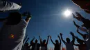 Pengunjung mengangkat tangan mereka untuk menerima energi matahari saat equinox musim semi di situs arkeologi Teotihuacan, Meksiko (21/3). Ritual ini dipercaya bisa mengalirkan energi positif serta mengusir roh jahat. (AP Photo/Rebecca Blackwell)