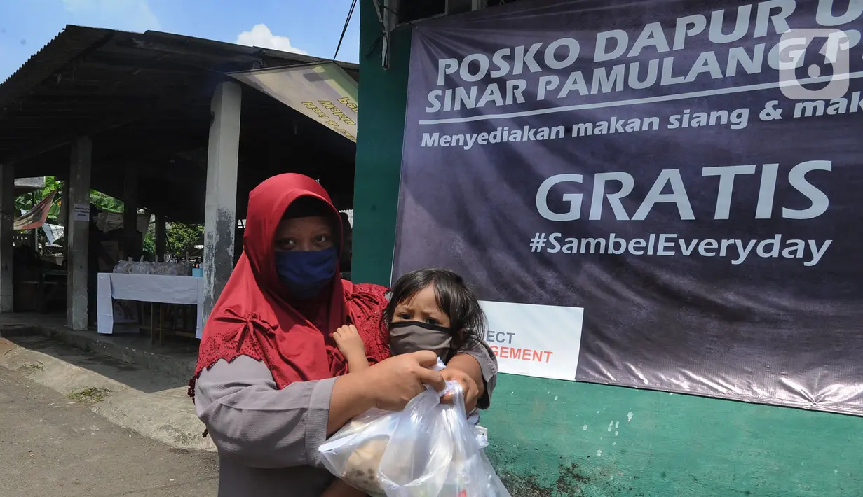 Seorang ibu menggendong anaknya sambil membawa nasi bungkus yang disediakan gratis di Kompleks Sinar Pamulang Permai, Pamulang Barat, Tangerang Selatan, Senin (13/4/2020).  (merdeka.com/Arie Basuki)