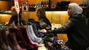 Pembeli melihat sepatu yang dibanderol dengan diskon selama Boxing Day di pusat kota London, Senin (26/12). Pada Boxing Day, pusat-pusat perbelanjaan London dan wilayah Inggris yang lain diserbu jutaan pemburu diskon. (DANIEL Leal-Olivas/AFP)