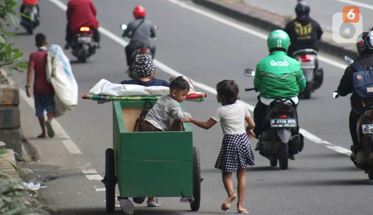 Pemulung melintas di Jalan Layang Prof DR Satrio, Jakarta, Kamis (30/4/2020). Setiap Ramadan tiba, kemunculan pemulung yang membawa gerobak marak terjadi. Saat ini, kemunculan mereka menjadi masalah tersendiri di tengah upaya memutus mata rantai penyebaran Covid-19. (Liputan6.com/Helmi Fithriansyah)