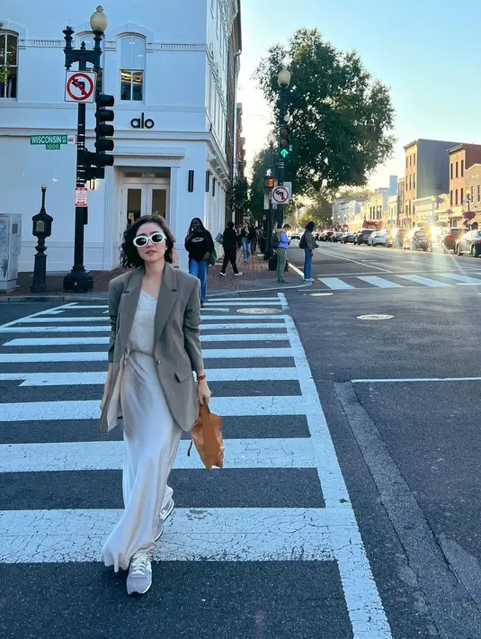 Ia tampil dengan chic mengenakan rok panjang dan tank top satin berkerah lace. [@febbyrastanty]