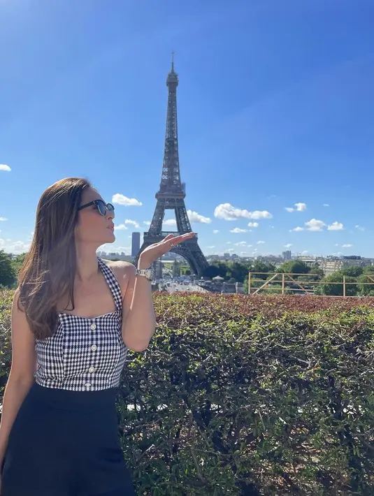 Berpose di menara Eiffel, Cut Tari tampil feminim mengenakan atasan motif kotak-kotak hitam yang serasi dengan warna bawahannya. @cuttaryofficial