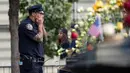 Petugas New York City Police Department (NYPD) mengusap wajahnya selama peringatan 16 tahun korban serangan 11 September di Museum dan Memorial Nasional 9/11, New York, Amerika Serikat, Senin (11/9). (Drew Angerer/Getty Images/AFP)