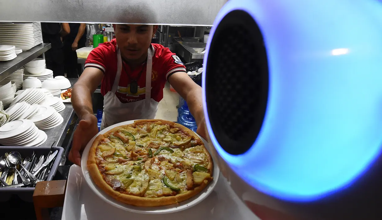 Pelayan robot buatan Nepal mengambil makanan dari dapur untuk dibawa ke pelanggan restoran Naulo di Kathmandu pada 26 Oktober 2018. Robot setinggi 1,5 meter ini diprogram untuk mengerti bahasa Inggris dan Nepal. (Prakash MATHEMA/AFP)