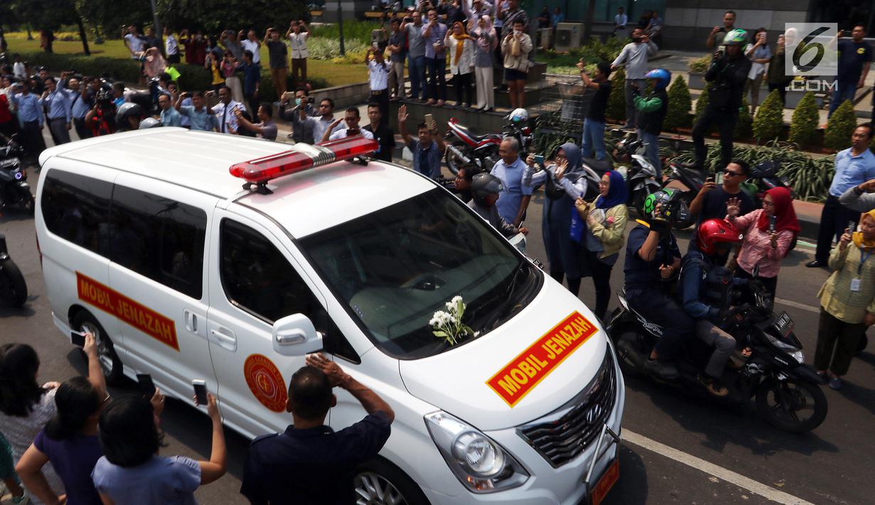 Warga mengambil gambar iring-iringan mobil jenazah yang membawa almarhum Presiden ke-3 RI, BJ Habibie saat melintasi Jalan Gatot Subroto menuju TMP Kalibata, Jakarta, Kamis (12/9/2019). BJ Habibie meninggal pada Rabu (11/9/2019) setelah menjalani perawatan di RSPAD. (Liputan6.com/Johan Tallo)