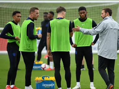 Pelatih Inggris Gareth Southgate berbicara dengan pemain selama sesi latihan di St George's Park di Burton-on-Trent, Inggris tengah (4/9). Inggris akan bertanding melawan Spanyol laga persahabatan internasional 8 September. (AFP Photo/Paul Ellis)