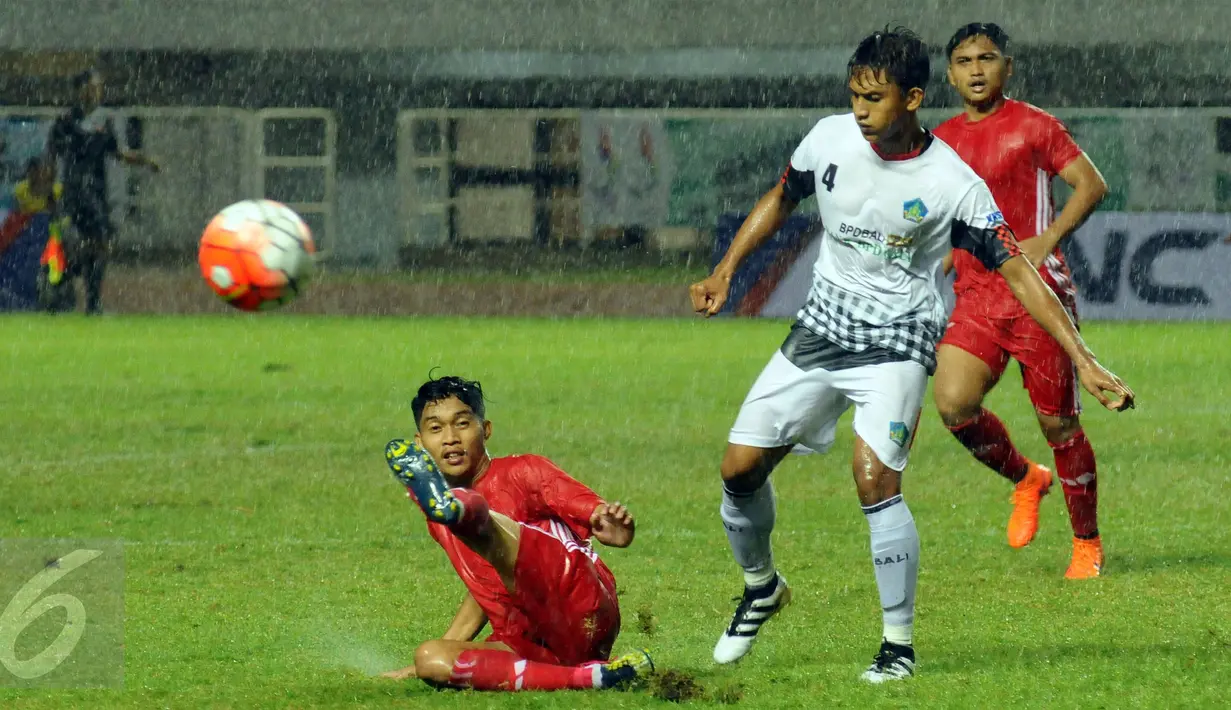 Pemain DKI Jakarta terjatuh usai berebut bola dengan bek Bali, I Nyoman Adi Parwa saat laga penyisihan Grup A PON XIX di Stadion Pakansari, Bogor, Rabu (14/9/2016). DKI Jakarta dan Bali bermain imbang 1-1. (Liputan6.com/Helmi Fithriansyah)