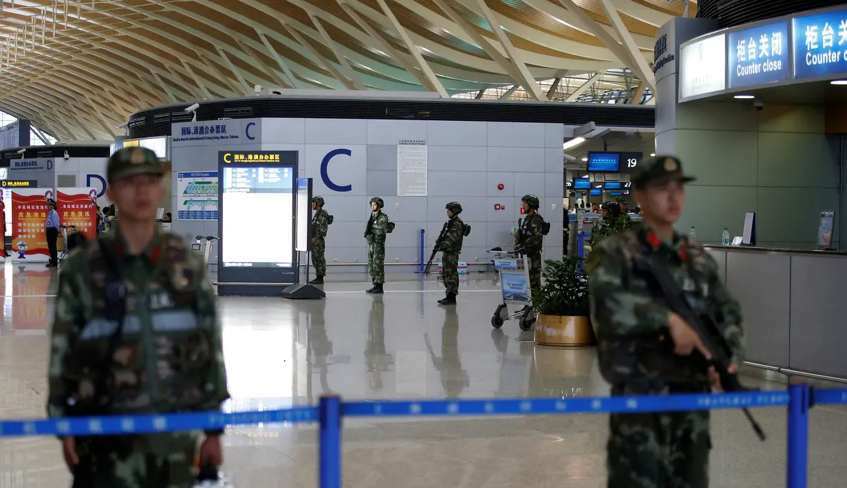 Polisi militer berjaga di dekat lokasi ledakan di Bandara Internasional Pudong, Shanghai, China, Minggu (12/6). Ledakan yang disebabkan "bahan peledak buatan" terjadi tak jauh dari lokasi penjuakan tiket di terminal dua bandara itu. (REUTERS/Aly Song)