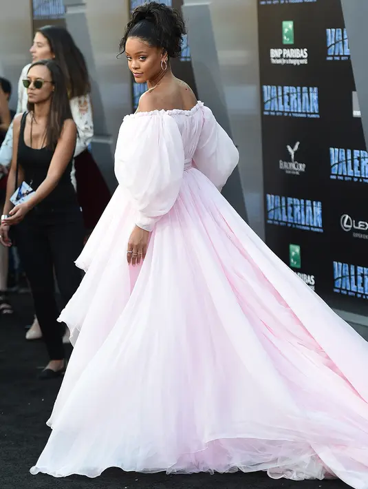 Rihanna berpose untuk fotografer pada pemutaran perdana "Valerian and The City of a Thousand Planets" di Los Angeles, 17 Juli 2017. Rihanna mengenakan gaun off-shoulder dengan siluet mini dress berwarna merah muda yang manis. (Jordan Strauss/Invision/AP)
