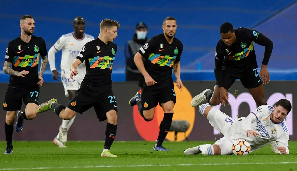 Pemain Inter Milan Denzel Dumfries (kanan atas) berebut bola dengan pemain Real Madrid Luka Jovic pada pertandingan sepak bola Grup D Liga Champions di Stadion Santiago Bernabeu, Madrid, Spanyol, 7 Desember 2021. Real Madrid menang 2-0. (OSCAR DEL POZO/AFP)
