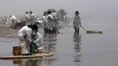 Petugas kebersihan bekerja untuk mengeluarkan minyak dari Pantai Cavero di Callao, Peru, 26 Januari 2022. Pembersihan Pantai Cavero dari tumpahan minyak kapal tanker Mare Doricum yang dihantam gelombang akibat letusan gunung berapi Tonga masih terus dilakukan. (Cris BOURONCLE/AFP)