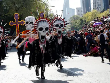 Peserta mengenakan kostum unik saat berpartisipasi dalam parade "Day of the Dead" di Mexico City, Meksiko, Sabtu, (29/10). Festival Kematian merupakan tradisi masyarakat Meksiko yang sudah dilakukan ratusan tahun lalu. (REUTERS / Carlos Jasso)