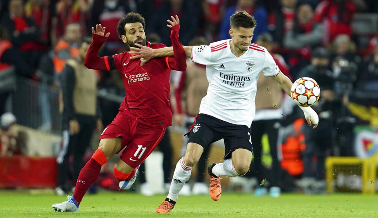 Pemain Liverpool Mohamed Salah (kiri) berebut bola dengan pemain Benfica Julian Weigl pada pertandingan sepak bola leg kedua perempat final Liga Champions di Stadion Anfield, Liverpool, Inggris, 13 April 2022. Pertandingan berakhir dengan skor 3-3. (AP Photo/Jon Super)