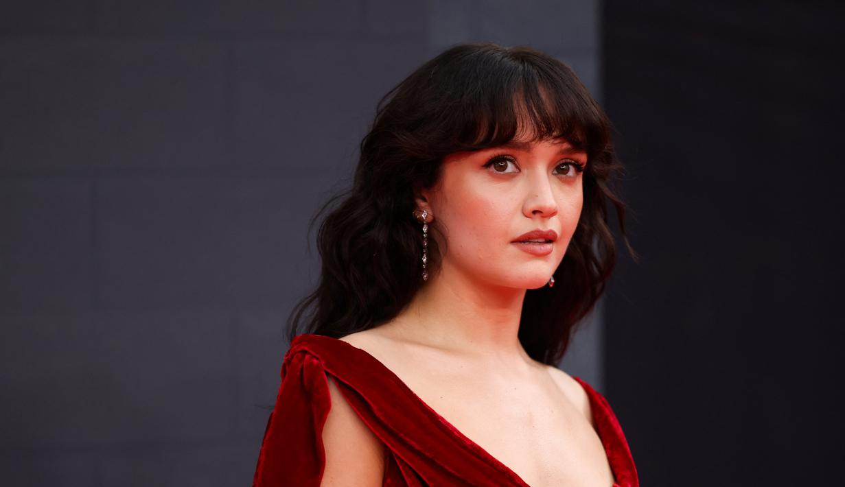 Olivia Cooke berpose di karpet merah saat tiba untuk menghadiri pemutaran perdana serial drama asli HBO "House of the Dragon" di Leicester Square Gardens, di London (15/8/2022). Aktris asal Inggris ini tampil memukau dengan gaun panjang lantai beludru merah. (AFP/Hollie Adams)