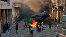 Demonstran antipemerintah membakar barang-barang saat pasukan keamanan menutup Rasheed Street selama bentrok di Baghdad, Irak, Kamis (28/11/2019). Sebanyak 27 demonstran antipemerintah tewas ditembak mati oleh pasukan keamanan Irak dalam sehari. (AP Photo/Khalid Mohammed)