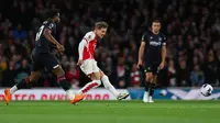 Gelandang sekaligus kapten tim Arsenal, Martin Odegaard melepaskan tendangan yang menghasilkan gol pertama timnya ke gawang Luton Town pada laga pekan ke-31 Premier League 2023/2024 di Emirates Stadium, London, Rabu (3/4/2024) malam. (AFP/Adrian Dennis)