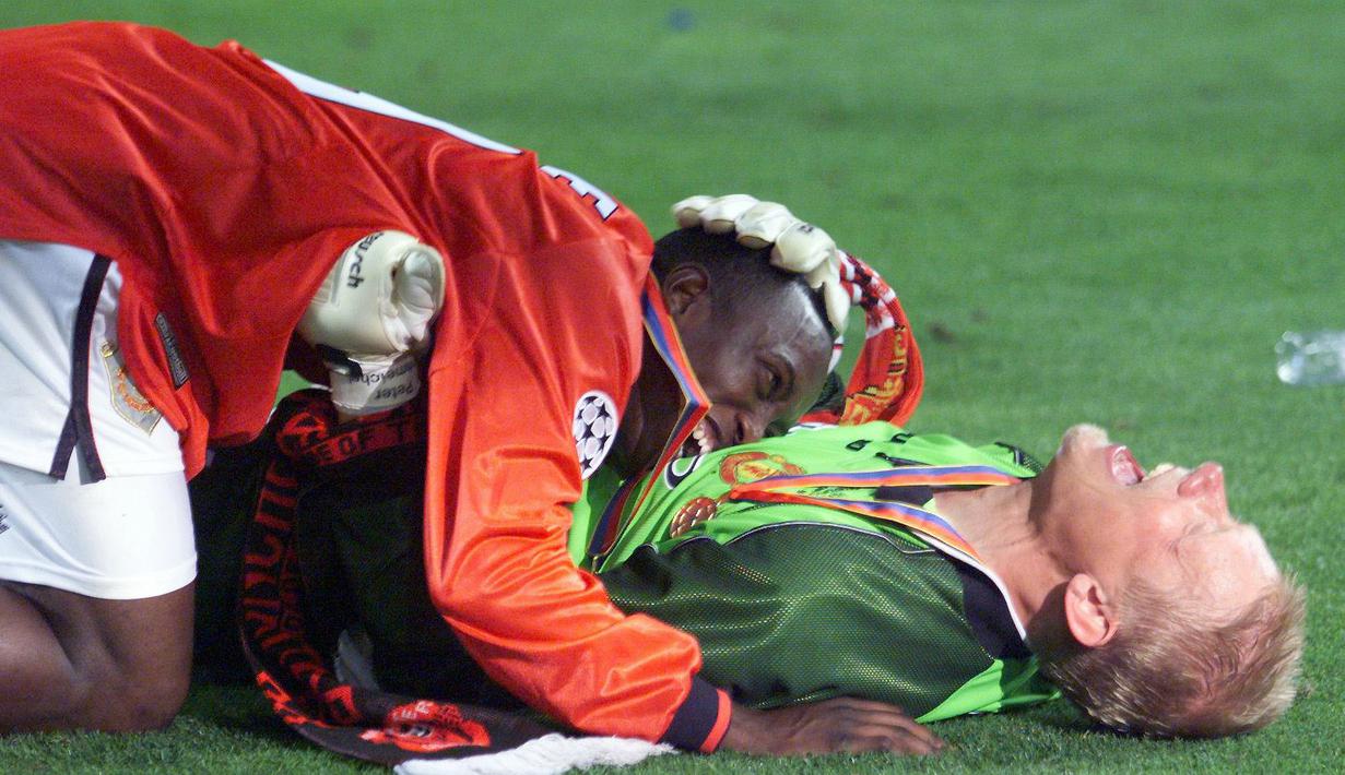 Pemain Manchester United, Peter Schmeichel dan Dwight Yorke melakukan selebrasi usai menjuarai Liga Champions di Stadion Camp Nou, Barcelona (26/5/1999). Manchester United menang 2-1 atas Bayern Munchen. (AFP/Eric Cabanis)