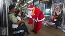 Sinterklas memberi hadiah kepada penumpang Kereta Commuter Line di Jakarta, Jumat (25/12/2015). Keberadaan Sinterklas ini merupakan bentuk pelayanan KCJ dalam memperingati hari Natal. (Liputan6.com/Angga Yuniar)
