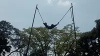 Nampak salah satu adegan tidur di atas seutas tali tambang yang diperankan pemain seni Lais Garut  (Liputan6.com/Jayadi Supriadin)