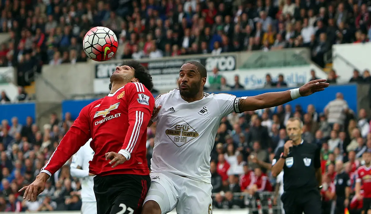 Pemain MU, Marouane Fellaini, berebut bola dengan pamain Swansea City, Ashley Williams di Stadion Liberty, Swansea, Wales, Inggris Raya. Minggu (30/8/2015). (EPA/Geoff Caddick)