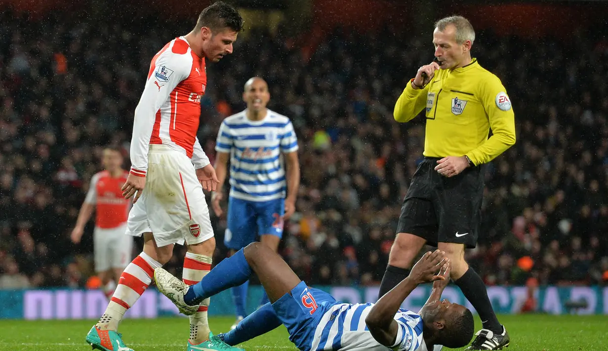 Striker Arsenal, Olivier Giroud, menyundul hingga menyebabkan bek QPR, Nedum Onuoha, terjatuh saat laga boxing day Premier League di Stadion Emirates, Inggris, Jumat (26/12/2014). (AFP/Glyn Kirk)