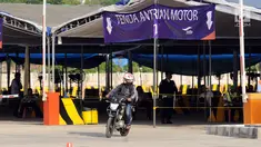 Pemudik melintasi lokasi antrian motor di dermaga 6 Pelabuhan Penyebrangan Merak-Bakauheni, Banten, Rabu (21/6). Hingga H-4 lebaran 2017, belum terlihat penumpukan penumpang baik di dermaga penumpang maupun kendaraan. (Liputan6.com/Helmi Fithriansyah)